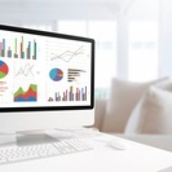Modern computer with keyboard and mouse on table showing charts and graph against comfortable room and pillow background in blue tone, Analysis Business, Statistics Concept.