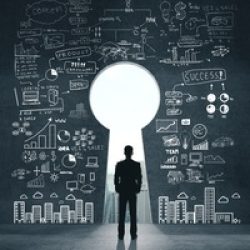 Businessman looking on drawing business sketch on concrete wall with door in form keyhole. Business and startup concept.